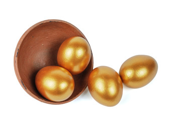 Golden Easter eggs in a clay bowl