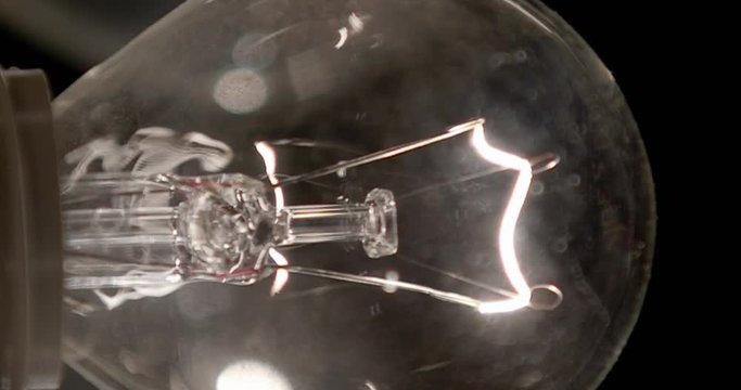Vertical video for phones and tablets. Real light bulb turning on, flickering and turning off. Macro.