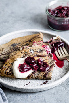 Toasty and nutty buckwheat crepes topped with roasted cherries, whipped cream, and bittersweet chocolate. A naturally gluten-free decadent dessert.