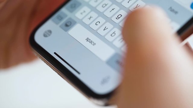 Hands typing text on smartphone close-up