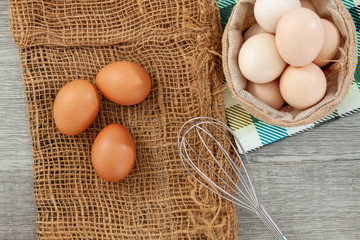 eggs in sack bag and basket on wooden table
