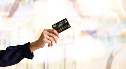 Close up of hand woman holding credit card for shopping with abstract blur mall background . Business shopping ideas concept. Web banner.