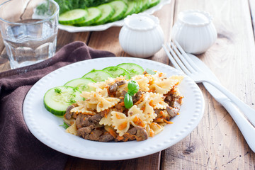 Farfalle with fried chicken liver and carrots, selective focus