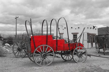 Fototapeta na wymiar Single color highlighted photo, Red, carriage in front of adobe southwest style building