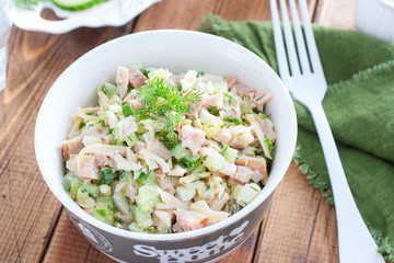 Smoked chicken salad with fresh cucumber in a white bowl, selective focus