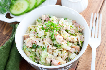 Smoked chicken salad with fresh cucumber in a white bowl, selective focus
