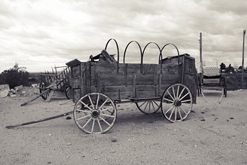 Fototapeta na wymiar Black and white filter photo of old west covered wagon with no canvas
