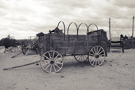 Black and white filter photo of old west covered wagon with no canvas