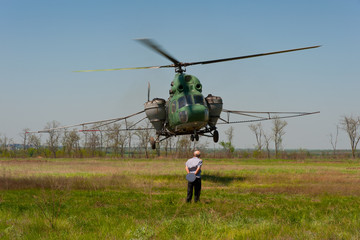 Pilot and helicopter over the field.