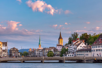 Fototapeta na wymiar Panoramic view of famous Fraumunster and Church of St Peter and river Limmat at sunrise in Old Town of Zurich, the largest city in Switzerland