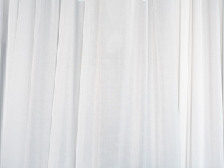 The white curtain is made of muslin fabric with soft sunlight in the morning passing through.