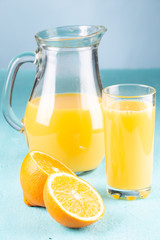 Jug with orange juice on a blue background