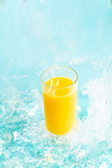 Glass of fresh orange juice in splashes of water