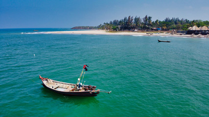Fototapeta premium NGWE SAUNG/MYANMAR - MARCH 14, 2020 : Burmese fishermen bear caught fish in baskets on the beach Ngwe Saung Myanmar