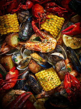 Mixed seafood including prawns, cray fish, mussels and clams, along with sweetcorn and potatoes