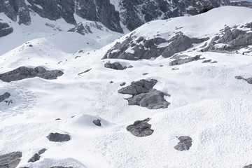 close up of snow and stones lying on the ground