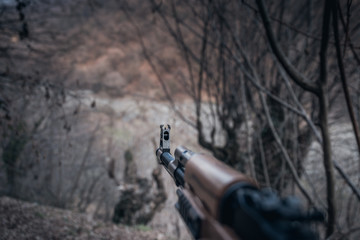 Shooter aiming target with assault rifle weapon. dangerous bandit holding gun in hand. Shooting...