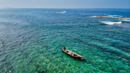 NGWE SAUNG/MYANMAR - MARCH 14, 2020 : Burmese fishermen bear caught fish in baskets on the beach Ngwe Saung Myanmar