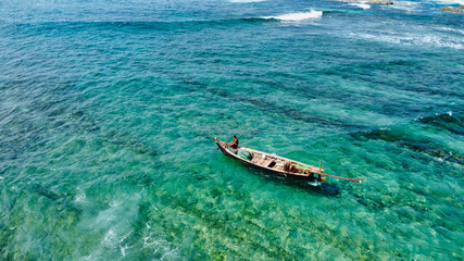 NGWE SAUNG/MYANMAR - MARCH 14, 2020 : Burmese fishermen bear caught fish in baskets on the beach Ngwe Saung Myanmar