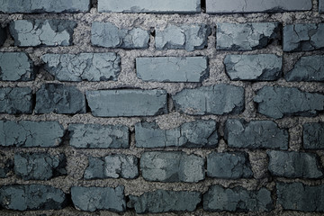 Texture of an old dark gray brick wall. Cracked bricks. Background.