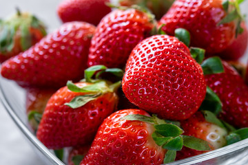 Close up of fresh strawberries in a glass bowl.