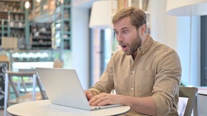 Wow, Excited Young Man in Shock on Laptop in Cafe