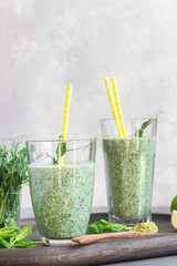 Healthy breakfast with green smoothie with matcha powder tea in glasses and ingredients on a wooden tray. Detox, diet, healthy, vegetarian food concept.
