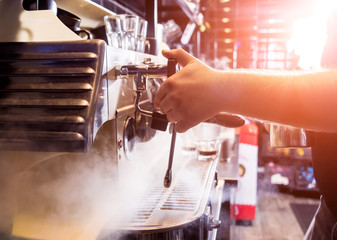 The bartender makes the coffee, cappuccino, cocoa, drink at the bar. 