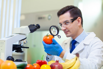 Laboratory worker examining fruits and vegetables and making analysis for pesticides and nitrates.