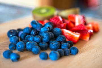 Strawberries, blueberries and kiwis in a wood table