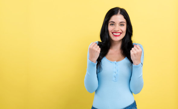 Successful young woman on a yellow background