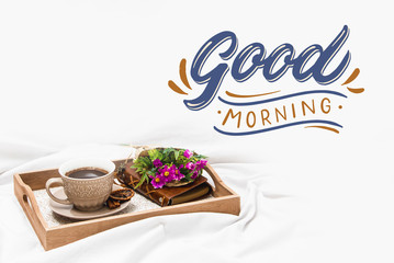 Fresh morning coffee on a board on a bed sheet with text Good Morning