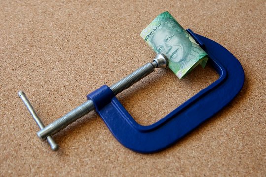 South African money in a clamp. Business recession concept image. 