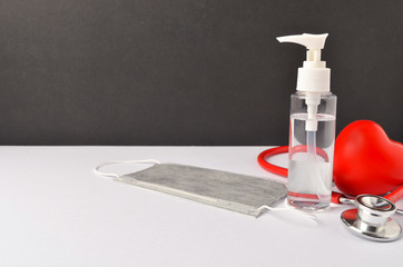 Hand sanitizer, stethoscope, face mask and red heart on white background. Conceptual image of staying hygienic during virus outbreak. 