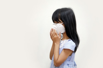 Side view of Asian girl was wearing a hygienic mask and sneezing, with two hands covering her mouth. On a white background with copy space.