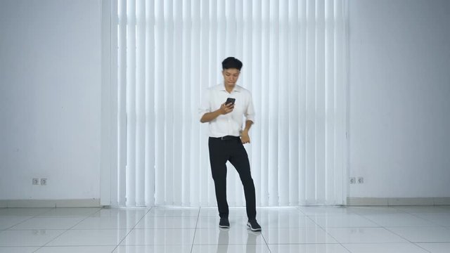 Businessman using phone and doing shuffle dance
