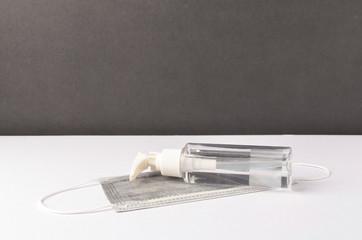 Hand sanitizer with face mask on white background.