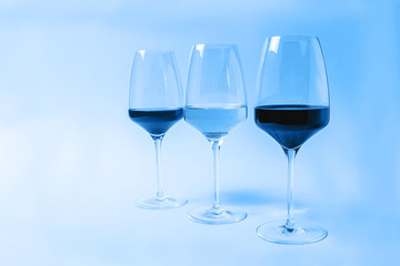 Wine in glasses toned in classic blue color.