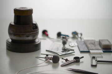 Various Engraver Tools On White Desk. Professional engraver equipment for jewelleries manufacturing Craftsman Engraver Jewellers Workplace Concept