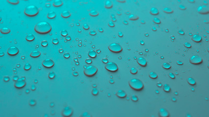 Many different drops of water rain on a turquoise background