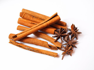 cinnamon sticks and dried herbs and spices with whole aromatic brown badia star anise or Illicium verum isolated on white background.