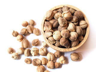 Top view of dried spices and herbs with siam cardamom (amomum krervanh pierre) in wooden bowl isolated on white background.