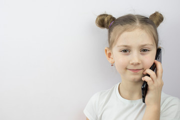 little girl talking on a smartphone , copy space, a place to place ads, text.