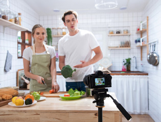 camera record video blog of couple cook in kitchen