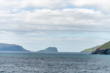 Fototapeta na wymiar View towards Skopunarfjordur near Kirkjubour in the Faroe Islands on Streymoy island as seen from Smyril ship to Suderoy