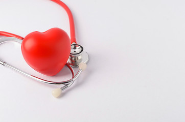 Stethoscope with red heart on white background.