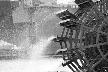 black and white close up of an old paddle wheel on the river - Powered by Adobe
