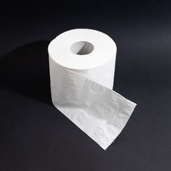 Toilet paper on a roll against a black background