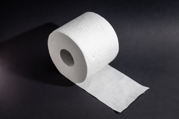 Toilet paper on a roll against a black background