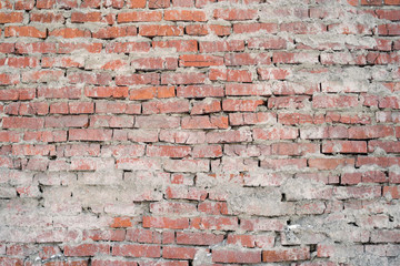 The texture of the brickwork from the old red brick. Exterior of the wall, traces of cement.